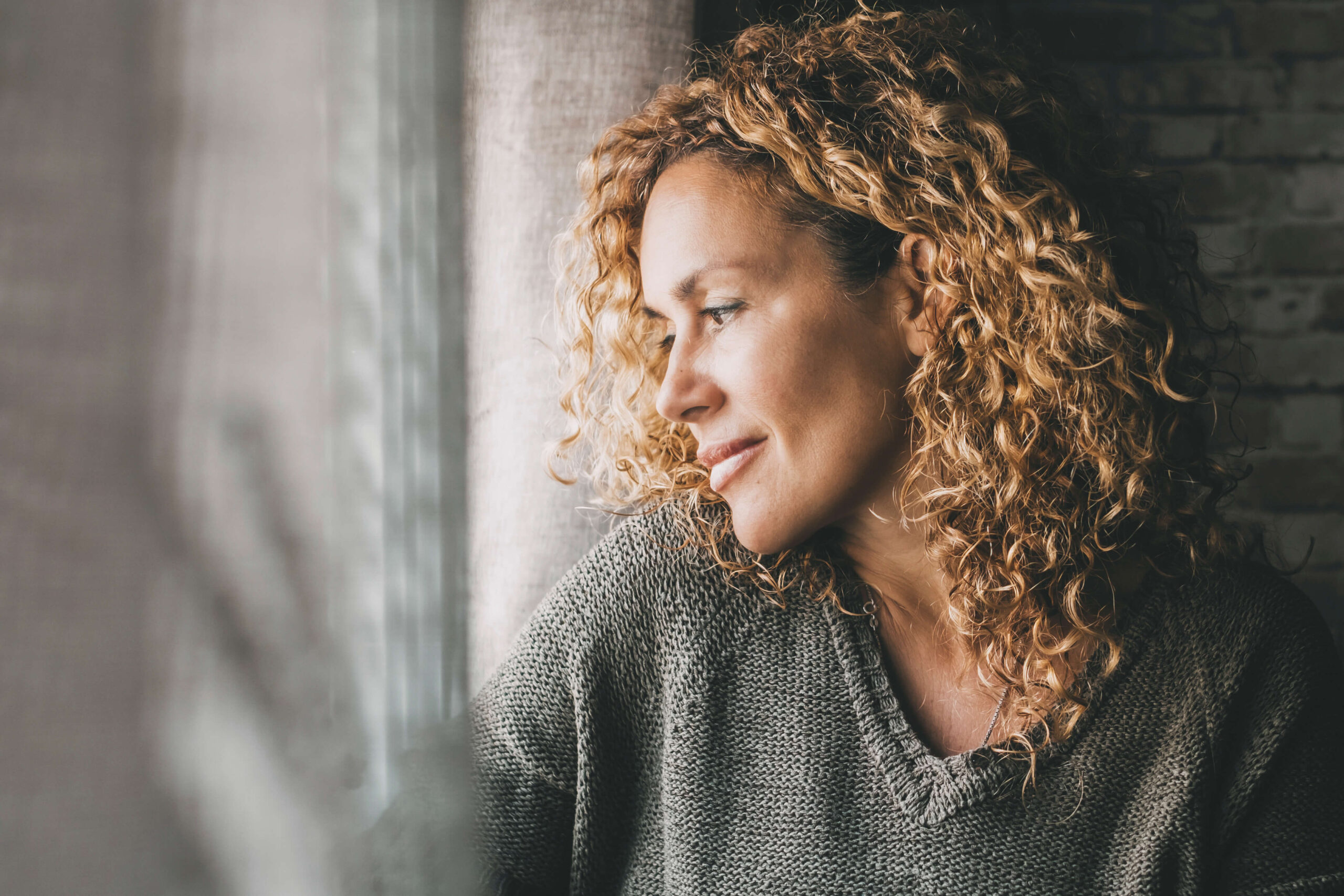 Adult woman looking outside the window